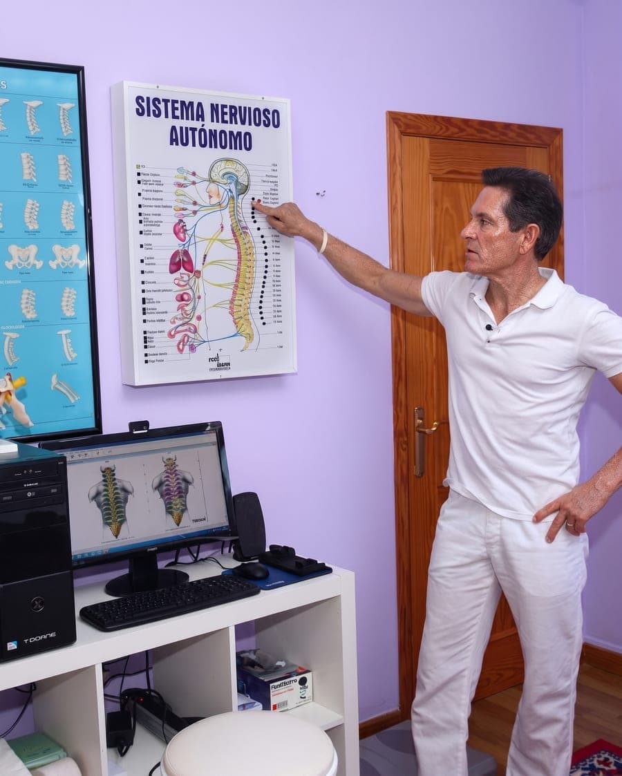 El Dr. Randall Jones señala una lámina del sistema nervioso autónomo, junto al ordenador donde muestra el análisis de la columna.